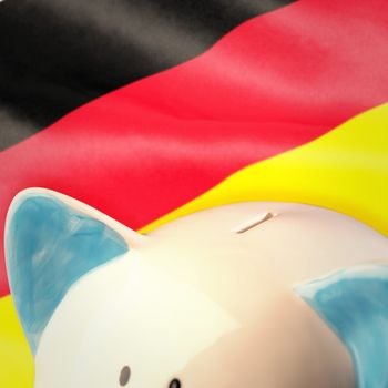 Piggy bank against digitally generated german national flag