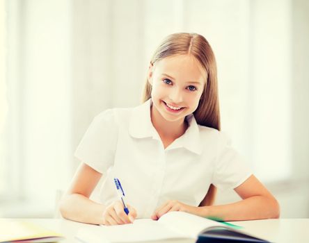 education and school concept - little student girl studying at school