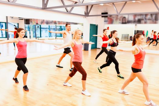 fitness, sport, training, gym and lifestyle concept - group of smiling people exercising in the gym