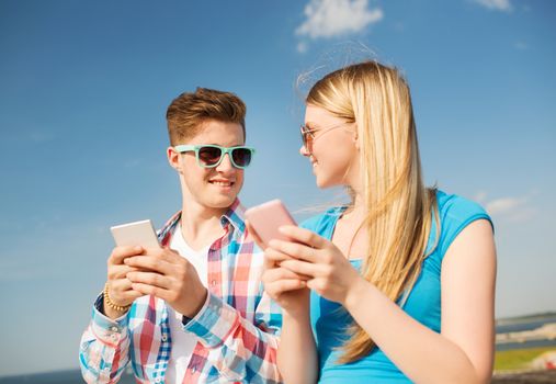 holidays, vacation, love and friendship concept - smiling couple having fun outdoors