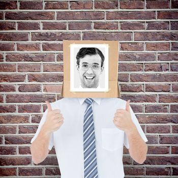 Businessman with photo box on head against red brick wall