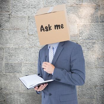 Anonymous businessman with diary against grey