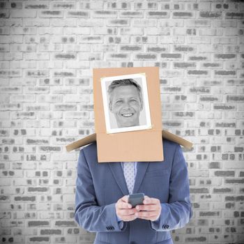 Businessman with photo box on head against grey brick wall