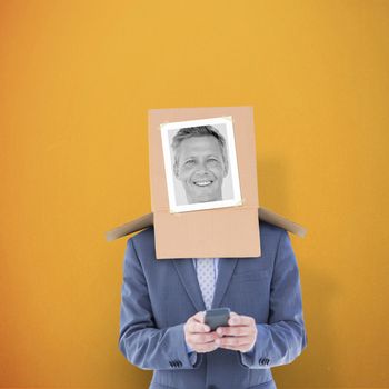 Businessman with photo box on head against orange background