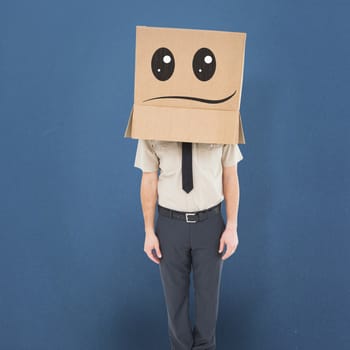 Businessman standing with box on head  against blue background