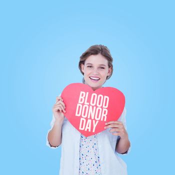 Woman holding heart card  against blue vignette background