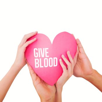 Couple holding a paper heart against give blood