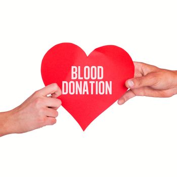 Hands holding red heart against blood donation