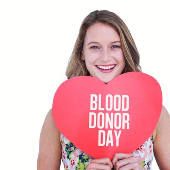 Woman holding heart card  against blood donor day
