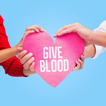 Couple holding a heart against blue vignette background