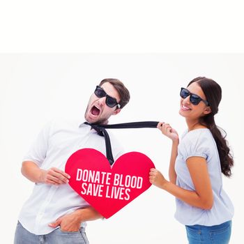 Brunette pulling her boyfriend by the tie holding heart against donate blood save lives