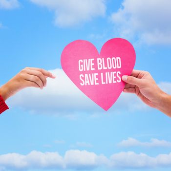 Couple holding a heart against sky 