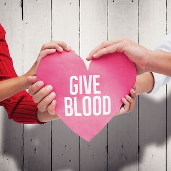 Couple holding a heart against white wood