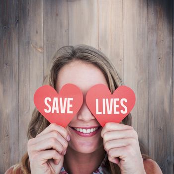 Woman holding heart cards  against wooden planks