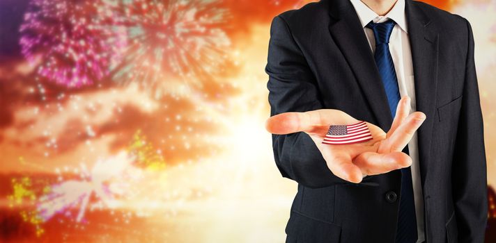 Mature businessman holding his hands out against colourful fireworks exploding on black background