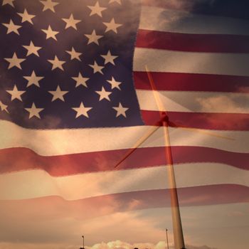 United states of america flag against windmill spinning against  blue sky