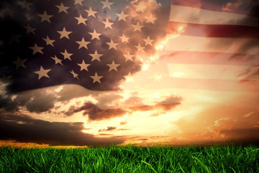 United states of america flag against green grass under blue and orange sky