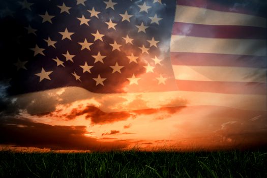 United states of america flag against green grass under blue and orange sky