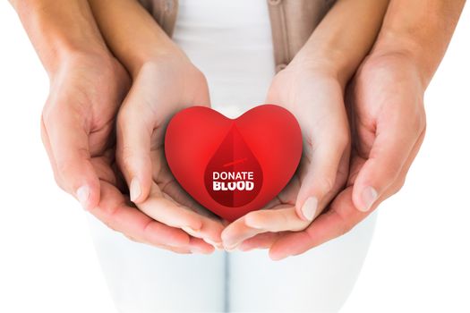 Couple holding miniature heart in hands against donate blood