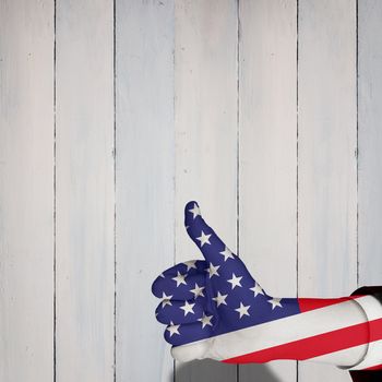 Hand showing thumbs up against wooden planks