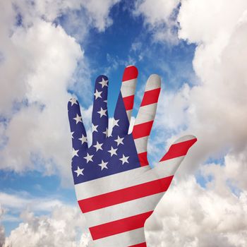 Hand with fingers spread out against blue sky with white clouds
