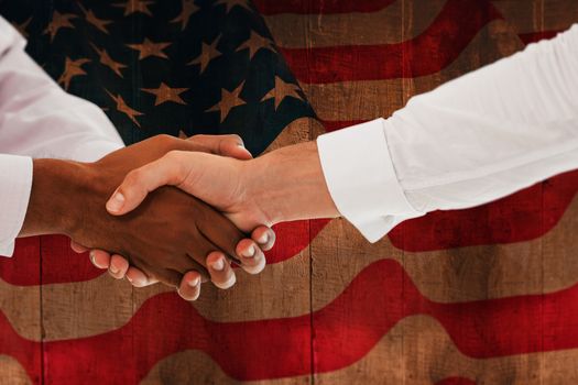 Close-up shot of a handshake in office against weathered oak floor boards background