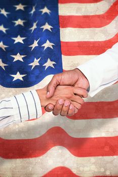 Business people shaking hands against paint splattered paper