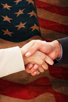 Close up on partners shaking hands against weathered oak floor boards background