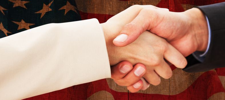 Close up on partners shaking hands against weathered oak floor boards background