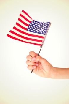 Hand waving american flag against white background with vignette