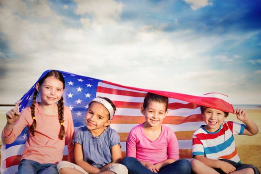 Children with american flag against serene beach landscape