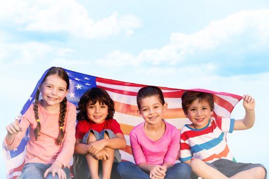 Children with american flag against blue sky