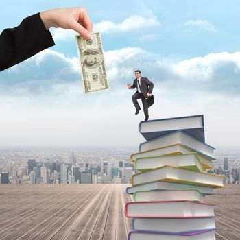 Cheerful businessman in a hurry against stack of books