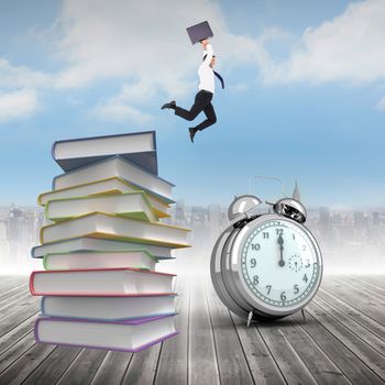 Smiling businessman leaping while briefcase against stack of books