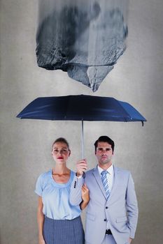 Business people holding a black umbrella against grey room
