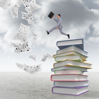 Businessman running with a suitcase against stack of books