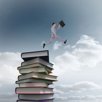Businessman running with a suitcase against stack of books