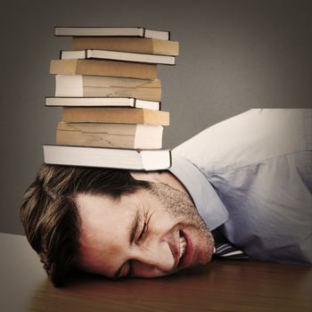 Casual businessman sleeping at his desk against grey background