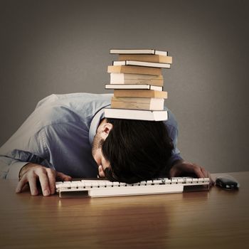 Businessman sleeping on his keyboard against grey background