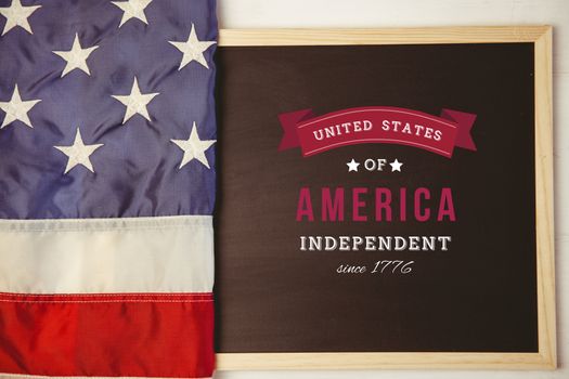 Independence day graphic against american flag on chalkboard