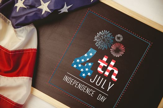 Independence day graphic against american flag on chalkboard