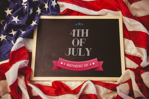 Independence day graphic against american flag on chalkboard