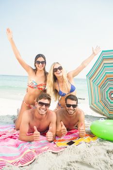 group of friends in swimsuits at the beach