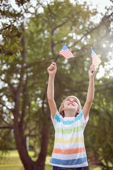 Young boy holding an american flag on a sunny day