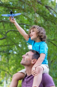 Father and son having fun in the park on a sunny day