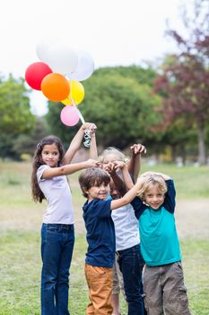 Happy children holding balloons on a sunny day