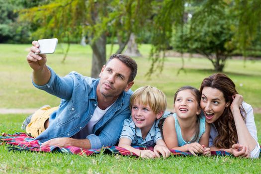 Happy family in the park taking selfie on a sunny day