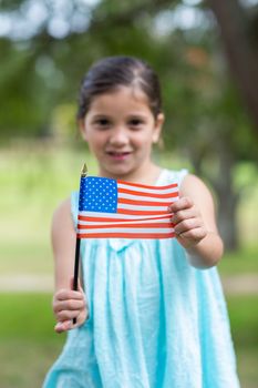 Little girl waving american flag on a sunny day