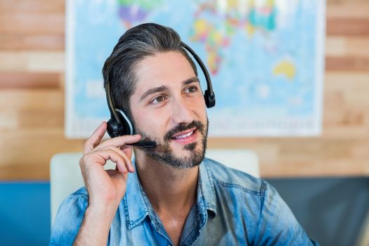 Smiling travel agent having phone call in the office