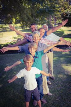 Happy family with arms outstretched in the park on a sunny day